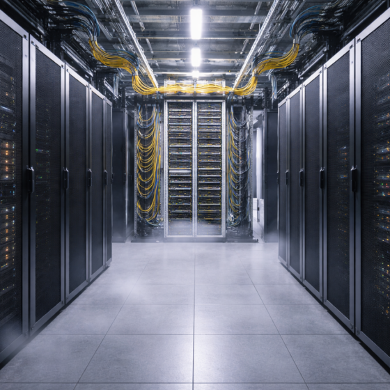 Data center corridor with fiber cross-connect frames and server racks, no text