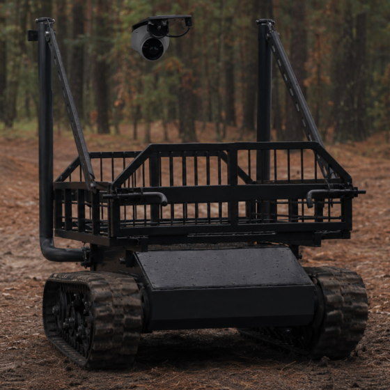 Technicians inspect a compact tracked ground robot for infantry support